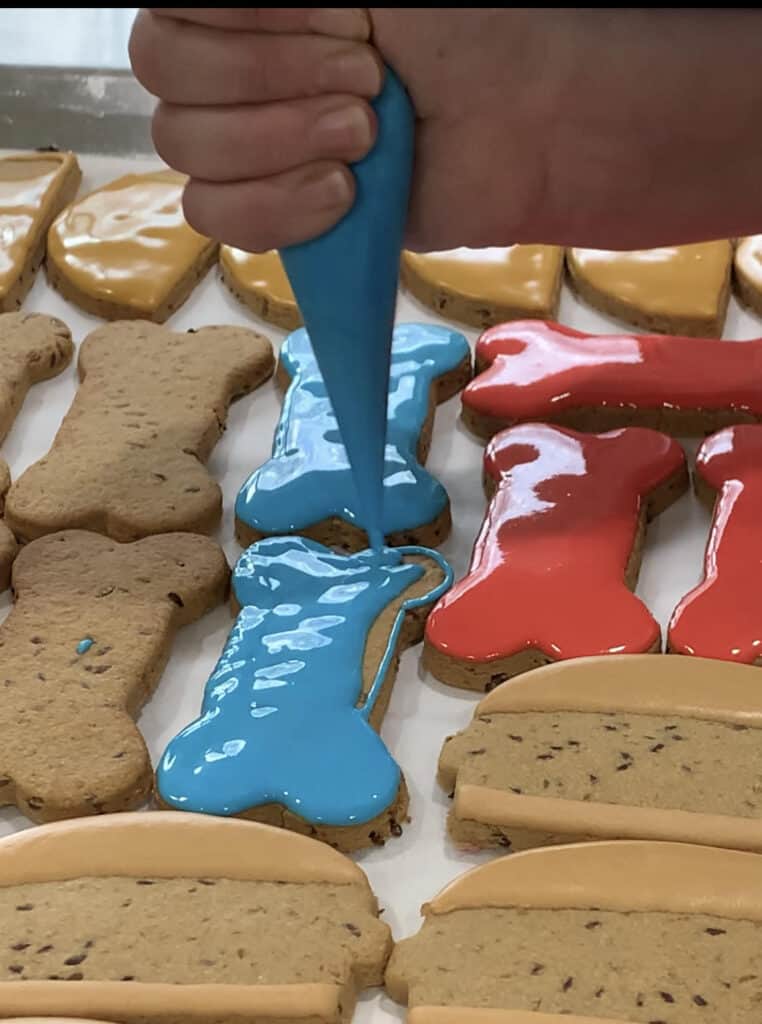 gluten free decorated dog treats applying frosting